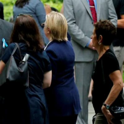Hillary Clinton kävelee pois WTC-tilaisuudesta avustajiensa ympäröimänä. 
