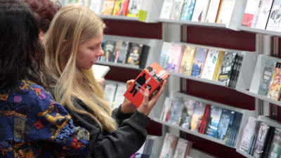 Unga är också intresserade av ljudböcker. Två ungdomar granskar en ljudbok i butikshyllan.