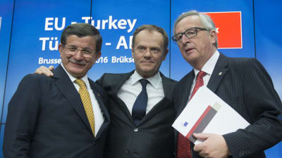 Turkiets premiärminister Ahmet Davutoğlu, Europeiska rådets ordförande Donald Tusk och EU-kommissionens ordförande Jean-Claude Juncker den 18 mars då EU och Turkiet slöt sitt flyktingavtal.