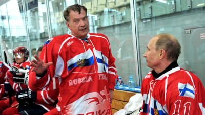 Sauli Niinistö och Vladimir Putin i hockeykläder. De pratar med varandra.
