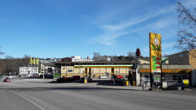 En bensinmack och en butik vid en gata.