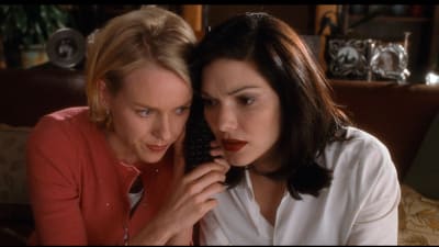 Vaalea ja tumma nainen istuvat ihan lähekkäin puhelin välissään, kuva elokuvasta Mulholland Drive.