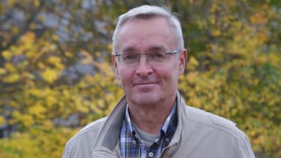 Mikko Silvast tittar in i kameran och ler. 