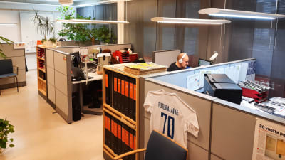 Bild av kontorsutrymme med flera avskärmade skrivbord.