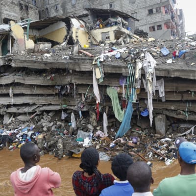Invånare i slumområdet Mathare i Nairobi står och tittar på det kollapsade huset.