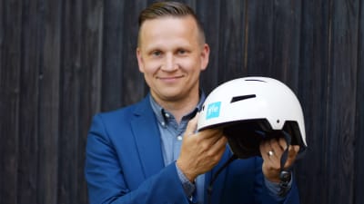 Polisen Mats Sjöholm håller i en vit hjälm. Hjälmen är i fokus.