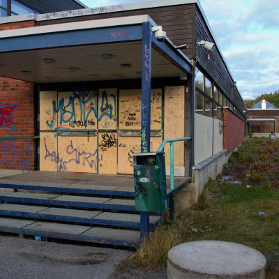 skolbyggnad i tegel som vandaliserats med graffiti.