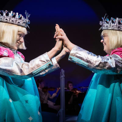 Två drottningar med händerna mot varandra på DUV-teatern.