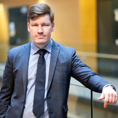 Mies katsoo kameraan.