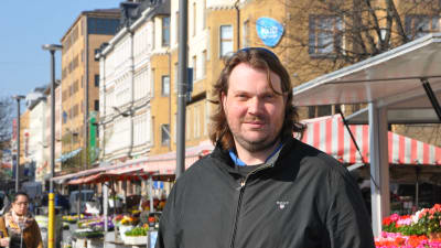 Janne Laine står vid Salutorget i Åbo och tittar in i kameran.