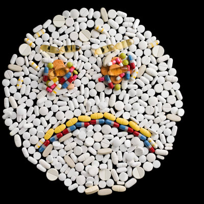 En bild av en sur gubbe, skapad av olika tabletter i olika färger.