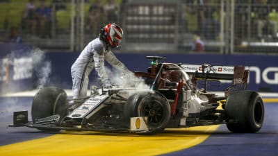 Kimi Räikkönen lämnar sin söndriga bil.