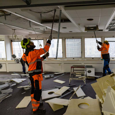 Rakennusmiehet purkavat kattopanelointia Spondan liikerakennuksessa, Mannerheimintie 14.