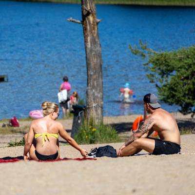 Människor sitter på en strand.