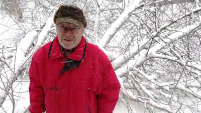 En man står ute i snötäckt landskap.