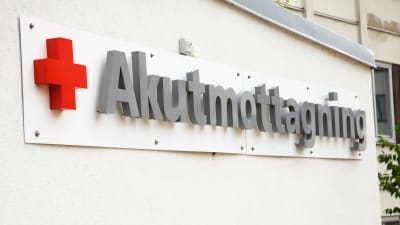 En vit vägg med skylten Akutmottagning monterad på väggen.