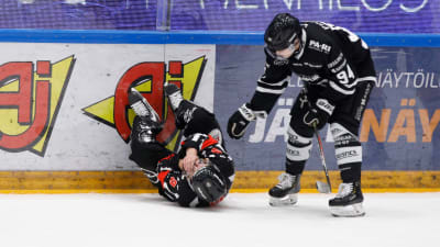 Domaren Jarno Heikkinen ligger på isen, Henrik Larsson lutar sig ner