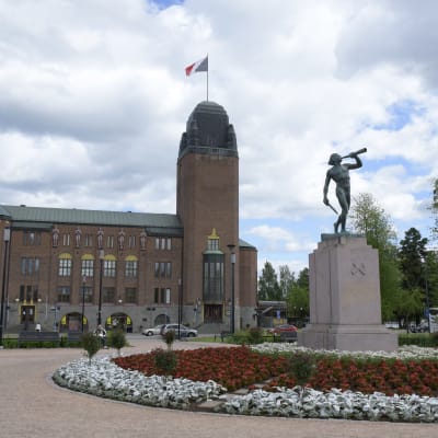 Joensuun kaupungintalo ja Vapaudenpatsas Vapaudenpuistossa kesäisenä päivänä.
