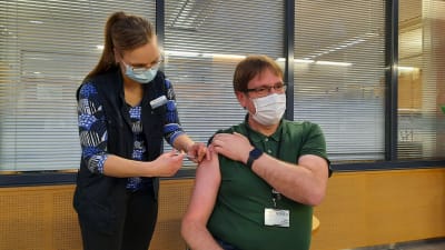 TyöPlussasta Mirjami Myllymäki antaa koronarokotteen infektioylilääkäri Marko Rahkosen käsivarteen
