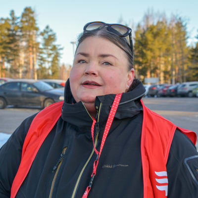 Karin Jensen utomhus vid en parkeringsplats. 