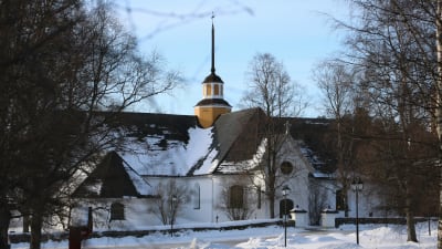En vit kyrka med svart tak.