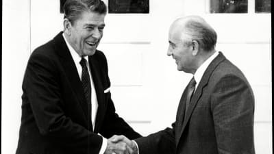 Ronald Reagan och Mihail Gorbatsov skrattar och skakar hand.