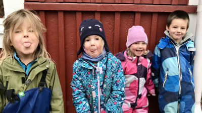 Fyra dagisbarn i galonkläder.