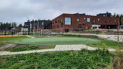 En stor brun tegelbyggnad vid en skolgård.