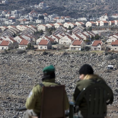 Kuvassa kaksi israelilaispoliisia valvoo etäältä Ofran siirtokuntaa Länsirannalla. 