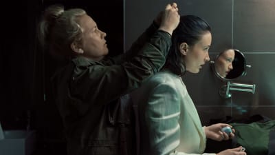 Rina (Eva Melander) hjälper Annika (Sannah Nedegård) att fixa hennes frisyr, Annika ser sig i spegeln. 