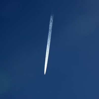 Lentokoneen aiheuttama tiivistymisjuova taivaalla.