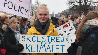 Linnea Jokinen håller upp skylt med texten "Skolstrejk för klimatet"