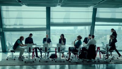 På bilden syns en grupp välklädda människor sitta i ett modernt och ljust konferensrum.