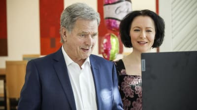 Sauli Niinistö och Jenni Haukio framför en datorskärm, tar emot valborgshälsningar. 