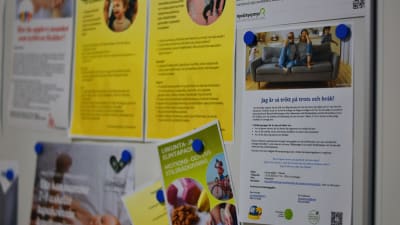 Anslagstavla med lappar med information om stöd för familjer.