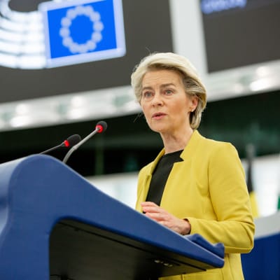 EU-kommissionens ordförande Ursula von der Leyen står i talarstolen. På sig har hon en gul kavaj och en svart blus. 