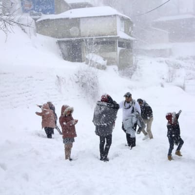 Människor står ute i snöövändet i Murree, 60 kilometer norr om Islamabad i Pakistan.