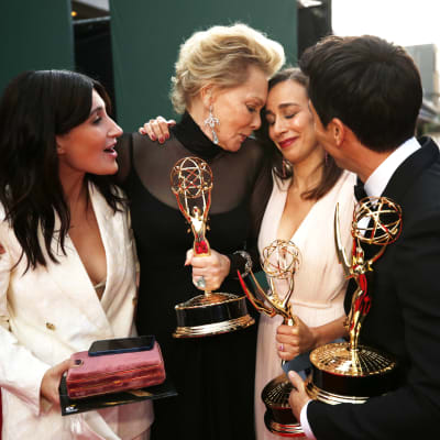 Ett gäng människor kramas med Emmystatyetter i armarna.