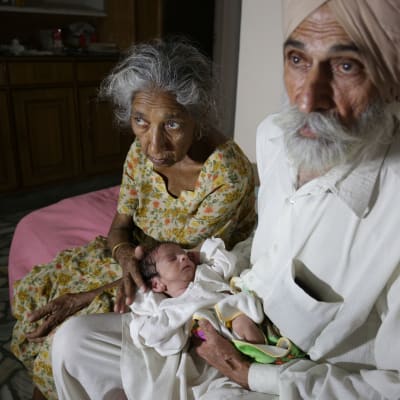 70-vuotias Dalwinder Kaur ja hänen 79-vuotias miehensä Mohinder Singh Gill ensimmäisen lapsensa, Armanin kanssa.