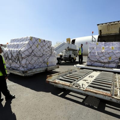 Arbetare lastar nödhjälp i form av vaccin på Sanas flygfält i Jemen. 