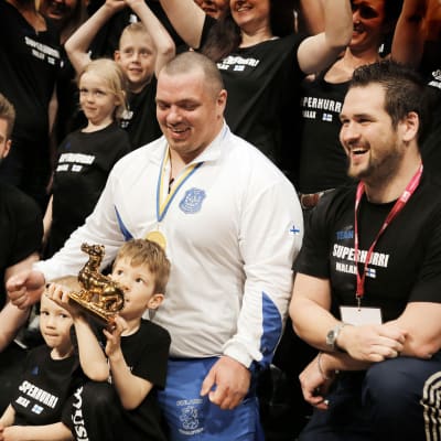 En busslast Malaxbor, inklusive barnen Felix och Viktor som håller i pokalen och Kristoffer ”Koffen” Nykopp längst till höger, följde Fredrik Smulters framgångar under fjolårets VM i Sundsvall.