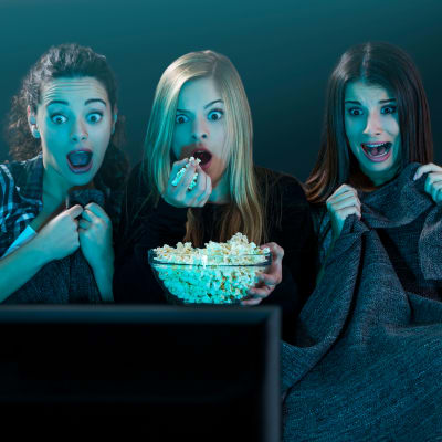 Tre ungdomar som tittar på skräckfilm. 