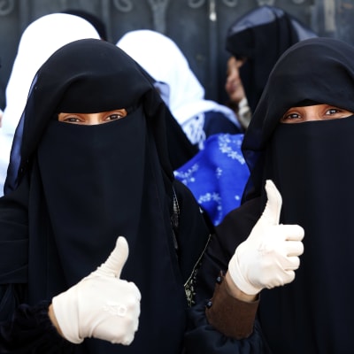 Två kvinnor i Jemens huvudstad Sanaa visar tummen upp för planerade fredssamtal i Sverige den här månaden  