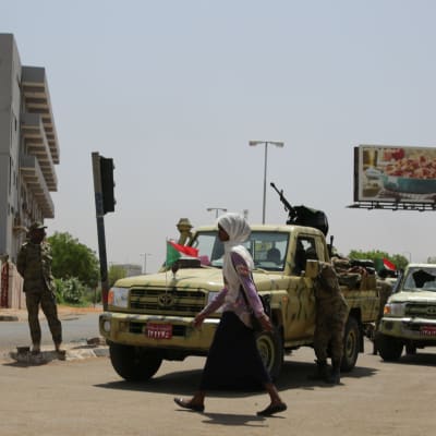 En kvina går förbi en av RSF-milisens vägspärrar i Khartoum