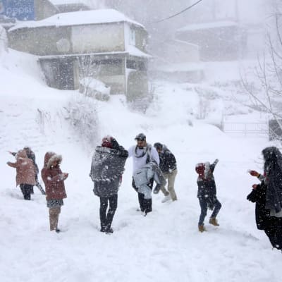 Människor står ute i snöövändet i Murree, 60 kilometer norr om Islamabad i Pakistan.