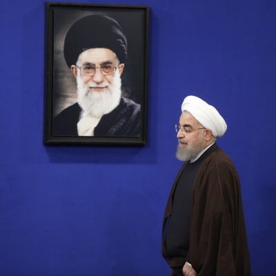 Ett arkivfoto på president Hassan Rouhani då han passerar ett porträtt av Irans högste ledare Ayatolla Ali Khamenei. 