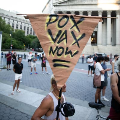En demonstrant håller en skylt med texten "Pox Vax now" under demonstration då över hundra aktivister samlades på Foley Square för att kräva att de federala och delstatliga regeringarna vidtar omedelbara åtgärder för att göra vaccinet mot apkoppor tillgängligt för alla som riskerar att smittas, så som HBTQIA-personer och sexarbetare.