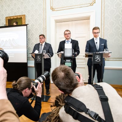 Timo Soini, Juha Sipilä och Alexander Stubb står på rad under en presskonferens.