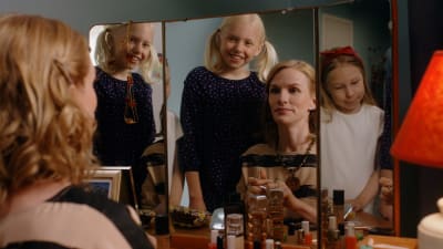 Vesta-Linnea tittar i en spegel tillsammans med sin mamma och lillasyster.