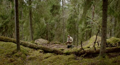 Skådespelaren Ville Virtanen går i en djup skog.